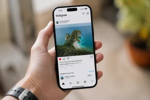Main tenant un smartphone avec l'application Instagram ouverte sur un post et l'icône like en cœur rouge visible