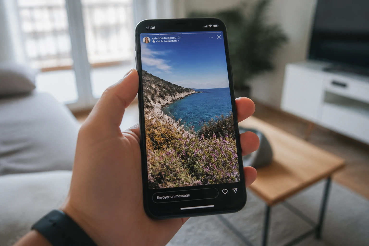 Smartphone affichant des stories Instagram tenu en main dans un intérieur lumineux