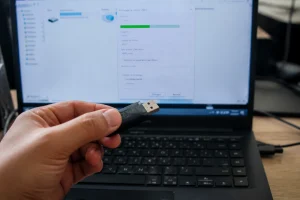 Main insérant une clé USB dans un ordinateur portable avec une fenêtre de formatage FAT32 à l'écran